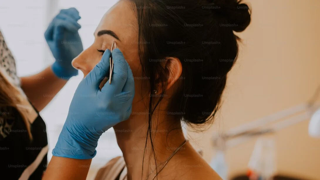 Mujer arreglando las cejas a otra Mujer arreglando las cejas a otra