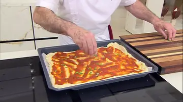 Cubre la masa de pizza con la salsa de tomate