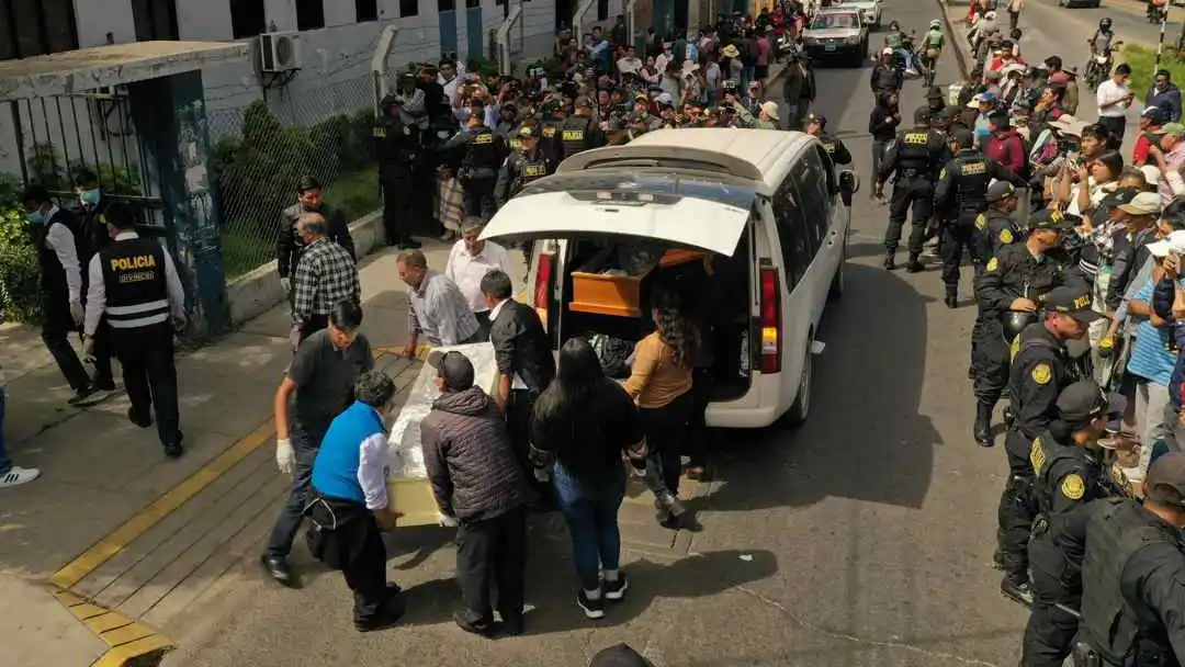 Varias personas cargan los f&eacute;retros con algunos de los cuerpos recuperados tras el incidente en la mina Yanaquihua