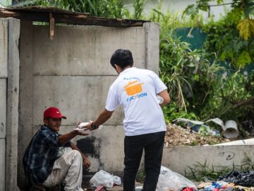 Un voluntario repartiendo comida