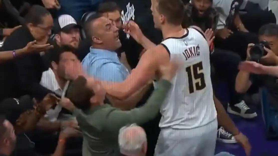 Nikola Jokic empujando al due&ntilde;o de los Suns