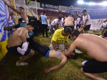 Fanáticos auxilian a personas durante una estampida en el Estadio Cuscatlán