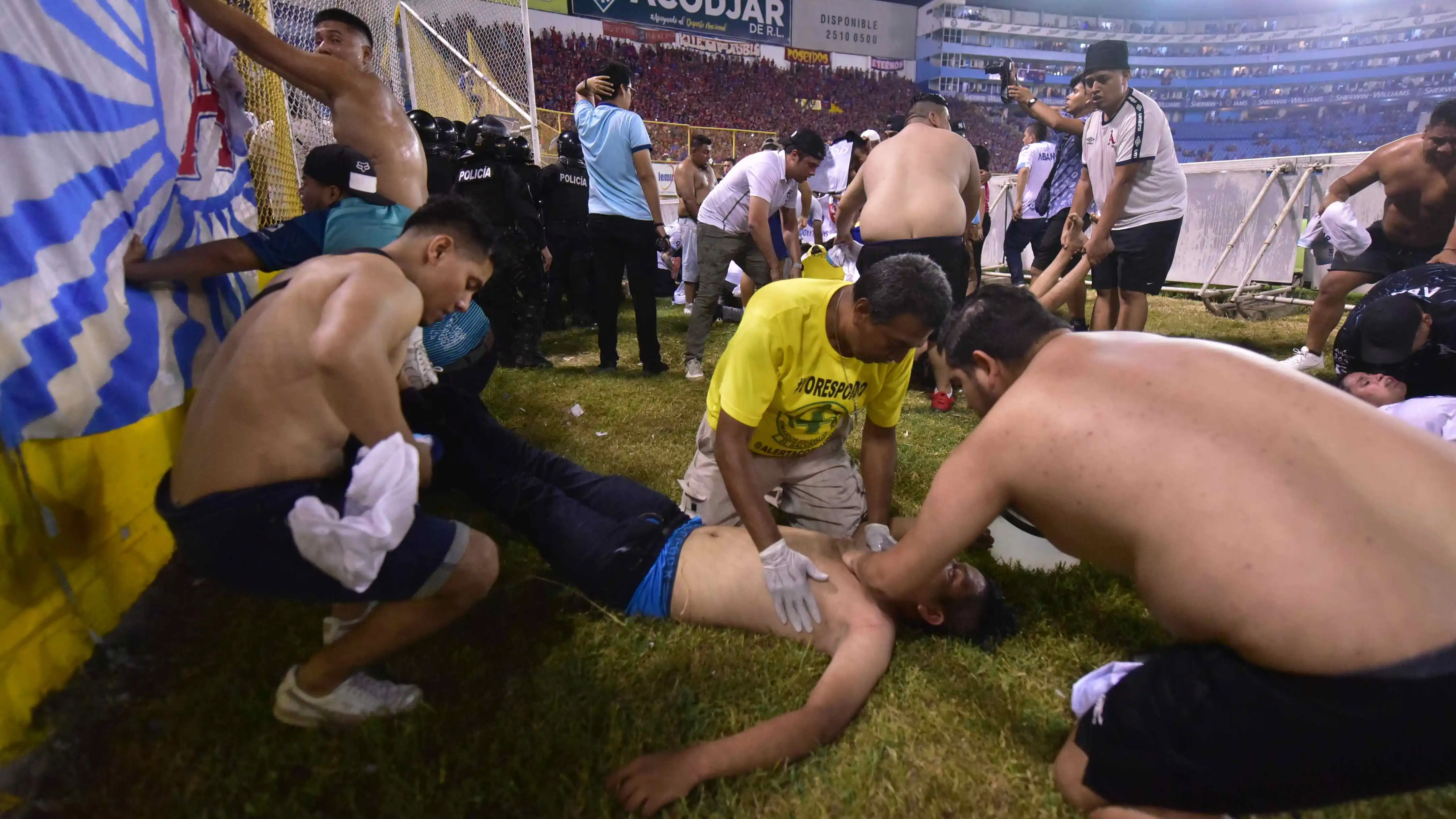 Fanáticos auxilian a personas durante una estampida en el Estadio Cuscatlán Fanáticos auxilian a personas durante una estampida en el Estadio Cuscatlán