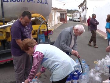 Vecinos llenando garrafas de agua de un camión cisterna