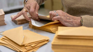 Una mujer mete la papeleta en el sobre de elecciones