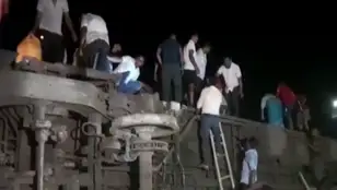 Decenas de personas ayudando a rescatar heridos tras un accidente de tren en la India