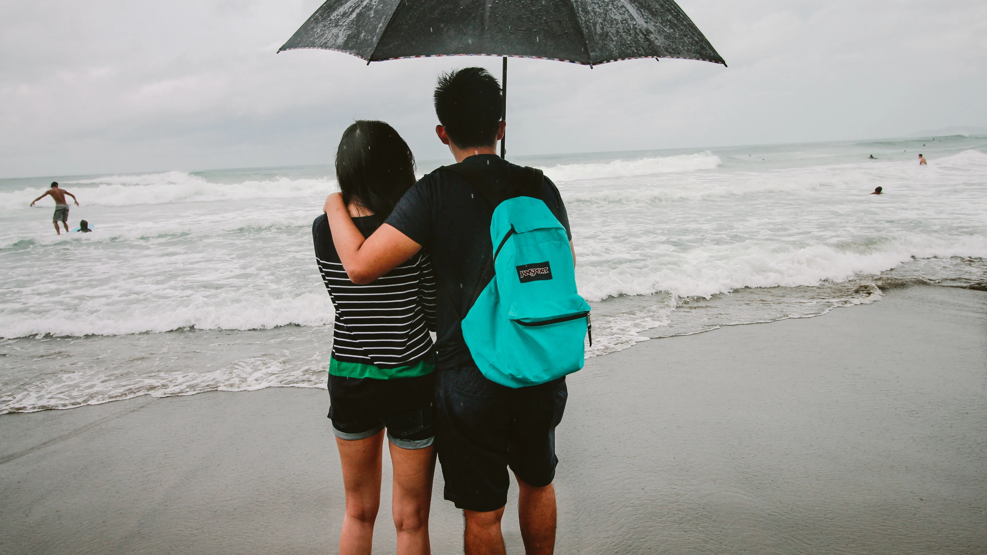 Una pareja en la playa un día de lluvia Una pareja en la playa un día de lluvia