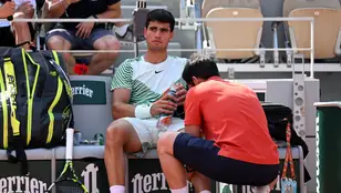 Carlos Alcaraz, atendido por un fisio tras lesionarse en las semifinales de Roland Garros
