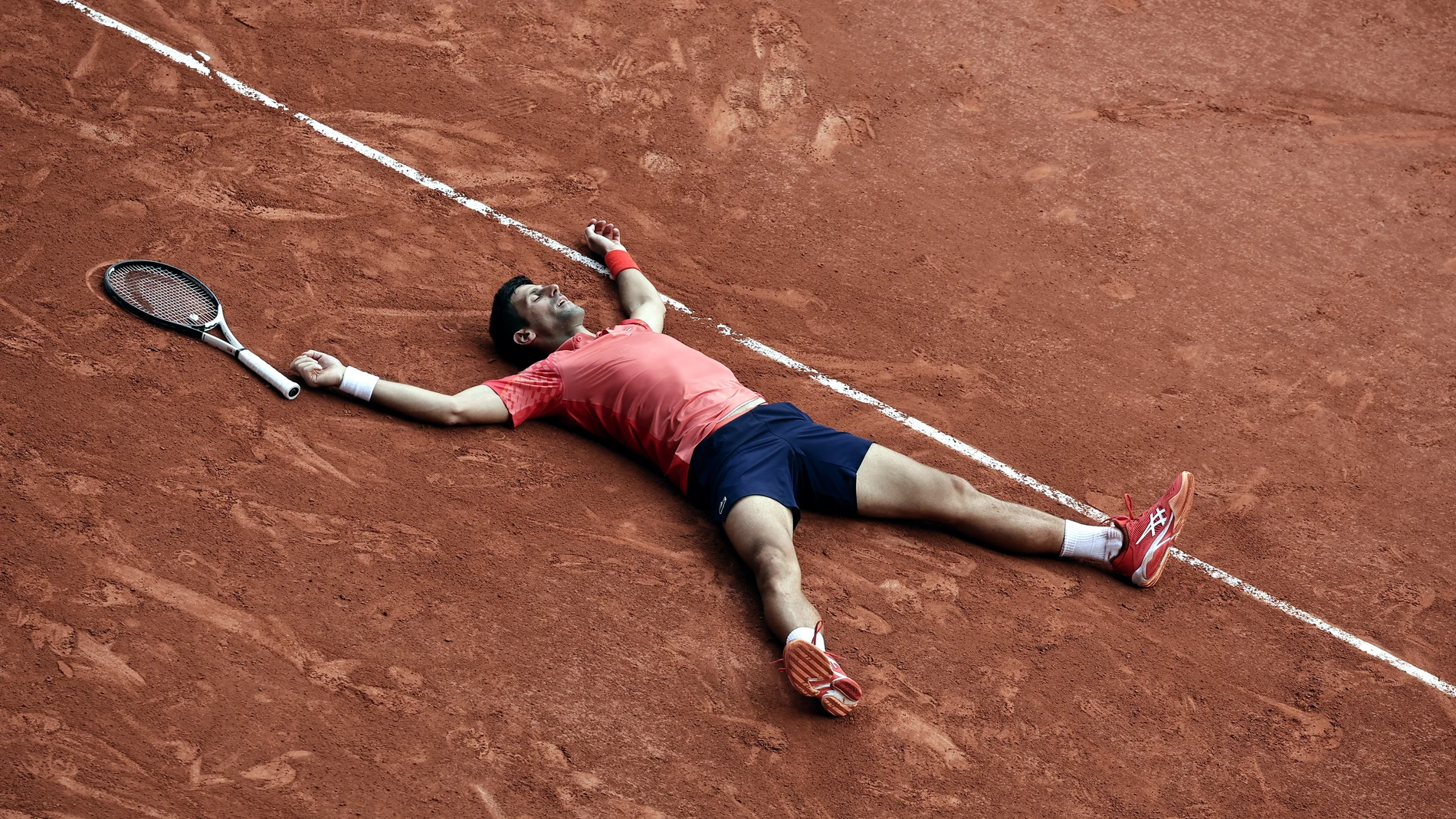 Djokovic, tirado en la tierra de Roland Garros tras ganar el torneo