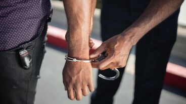 Agente de Polic&iacute;a poniendo las esposas a un detenido