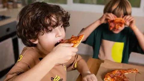 Niños comiendo pizza