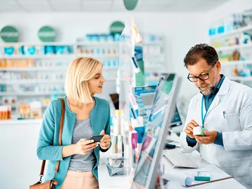 Un farmacéutico atiende a una clienta Un farmacéutico atiende a una clienta
