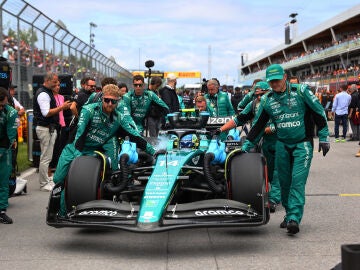 Los mecánicos de Aston Martin empujan el coche de Fernando Alonso en Canadá