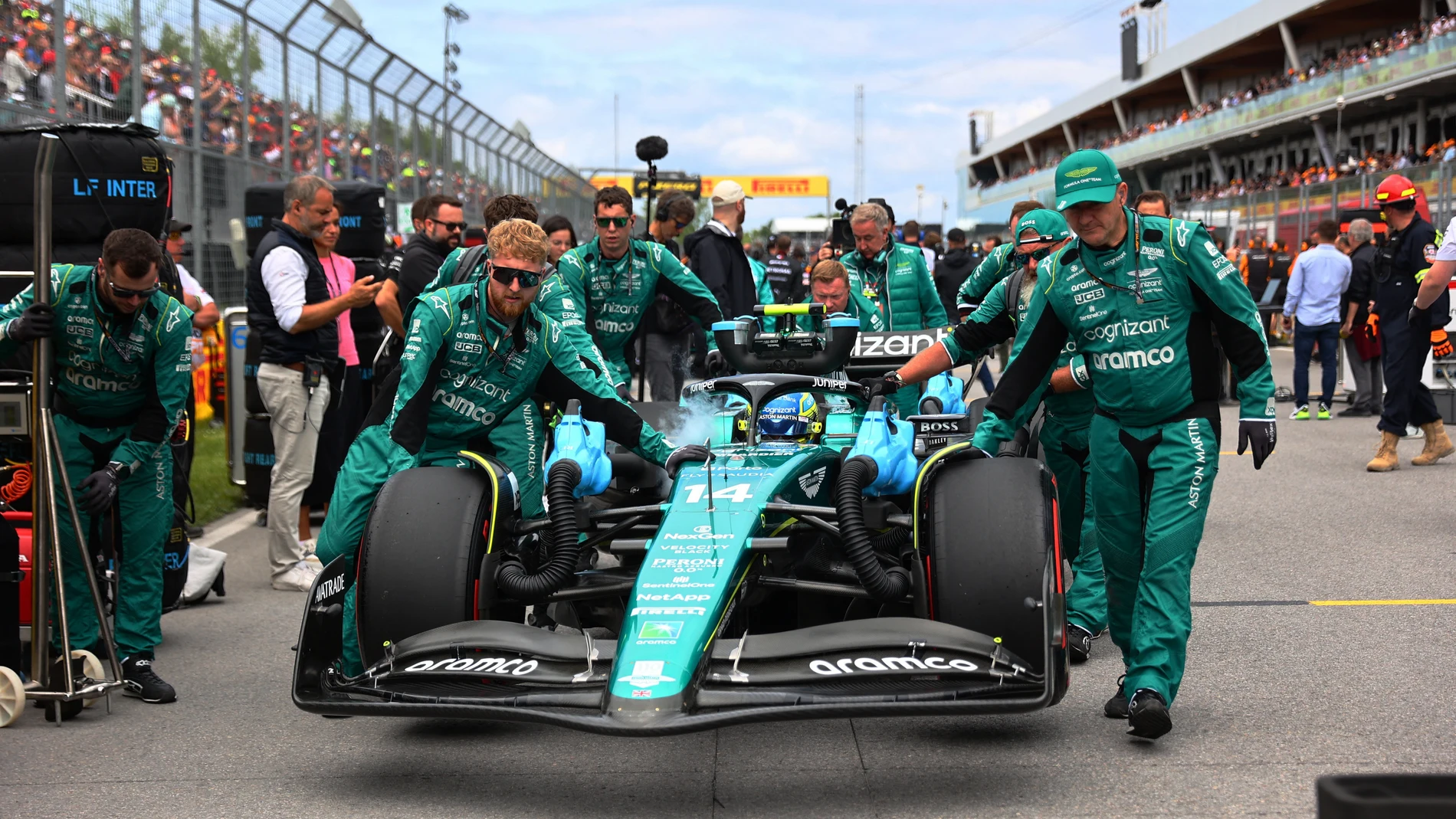 Los mecánicos de Aston Martin empujan el coche de Fernando Alonso en Canadá Los mecánicos de Aston Martin empujan el coche de Fernando Alonso en Canadá