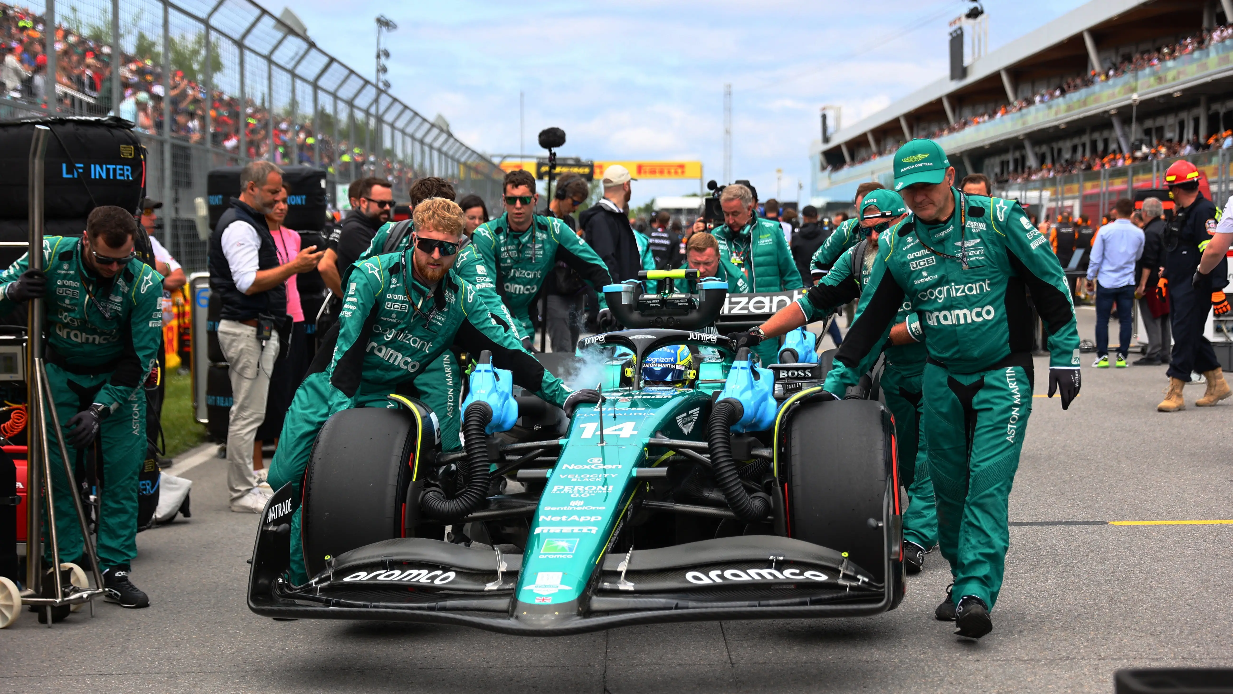 Los mec&aacute;nicos de Aston Martin empujan el coche de Fernando Alonso en Canad&aacute;