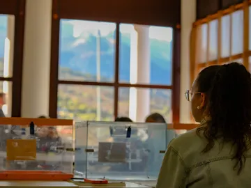 Imagen de archivo de una mujer sentada en una mesa electoral Imagen de archivo de una mujer sentada en una mesa electoral