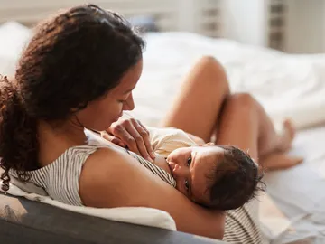 Una madre amamanta a su bebé Una madre amamanta a su bebé
