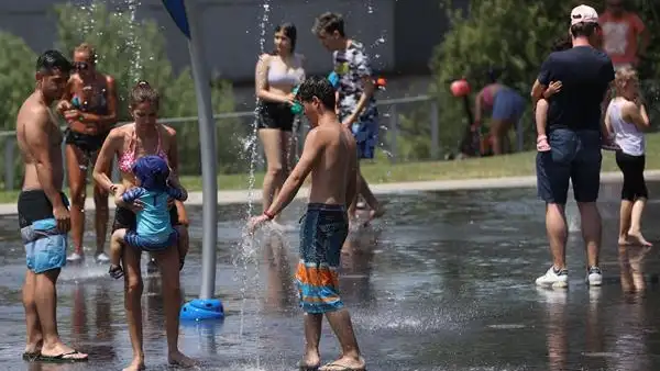 Un grupo de gente refresc&aacute;ndose en una fuente