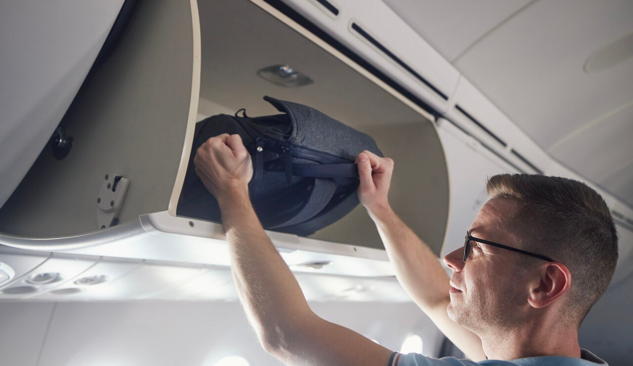 Hombre viajando con una mochila en el avi&oacute;n