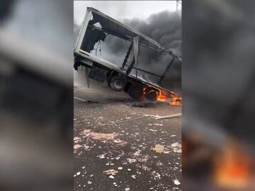 Un camión en llamas  se queda colgando de un puente