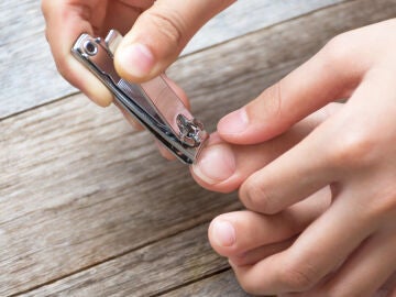 Persona cortándose las uñas