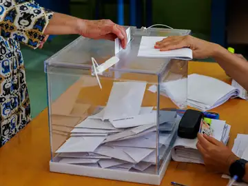 Una mujer depositando su voto Una mujer depositando su voto
