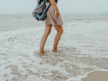 Mujer caminando por al orilla del mar