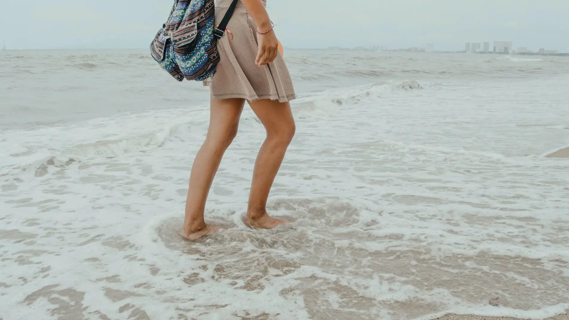 Mujer caminando por al orilla del mar