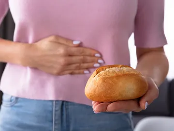 Mujer con un panecillo en la mano Mujer con un panecillo en la mano