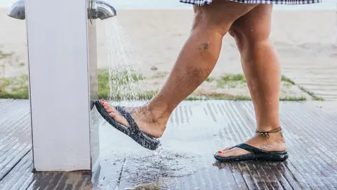 Quitarse la arena en la ducha de la playa Quitarse la arena en la ducha de la playa