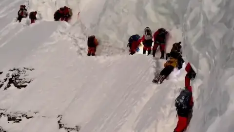 El sherpa, vestido de amarillo, en el cuello de botella del K2 El sherpa, vestido de amarillo, en el cuello de botella del K2