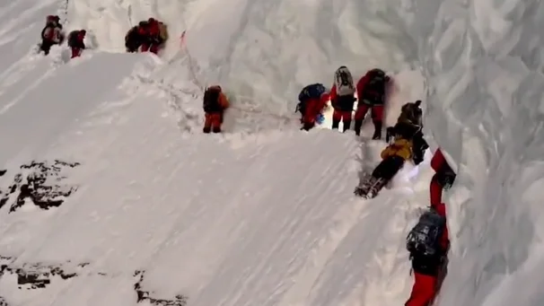 El sherpa, vestido de amarillo, en el cuello de botella del K2