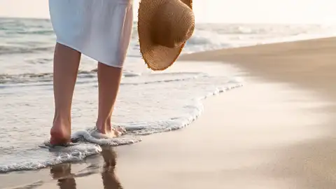 Una mujer paseando por la orilla de la playa