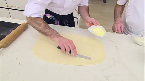 Después de estirar la masa, unta mantequilla y añade el relleno Después de estirar la masa, unta mantequilla y añade el relleno
