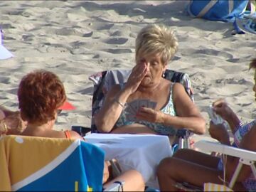 Personas mayores jugando a las cartas en la playa