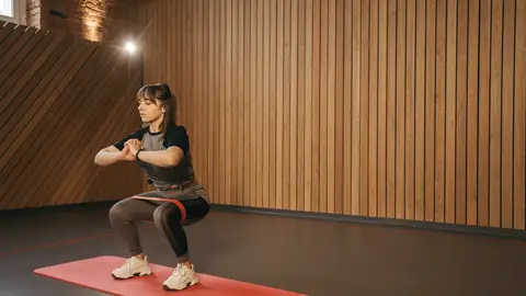 Mujer practicando sentadillas Mujer practicando sentadillas