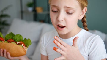 Una niña se come un bocadillo