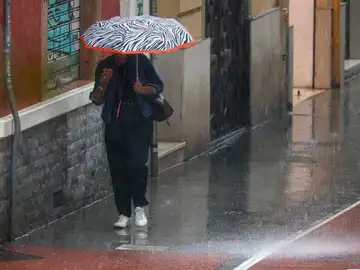 Una mujer camina bajo la lluvia en Valencia Una mujer camina bajo la lluvia en Valencia