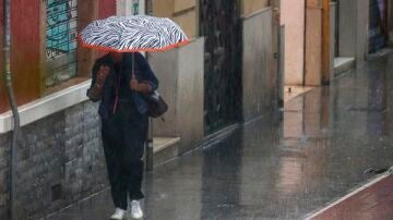 Una mujer camina bajo la lluvia en Valencia