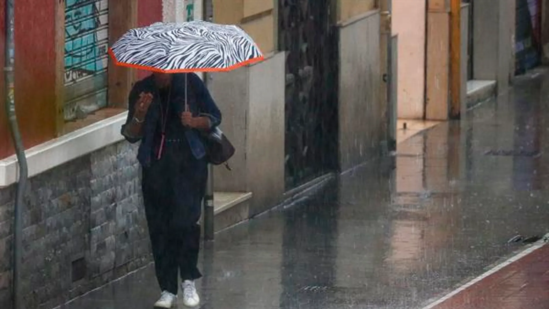 Una mujer camina bajo la lluvia en Valencia
