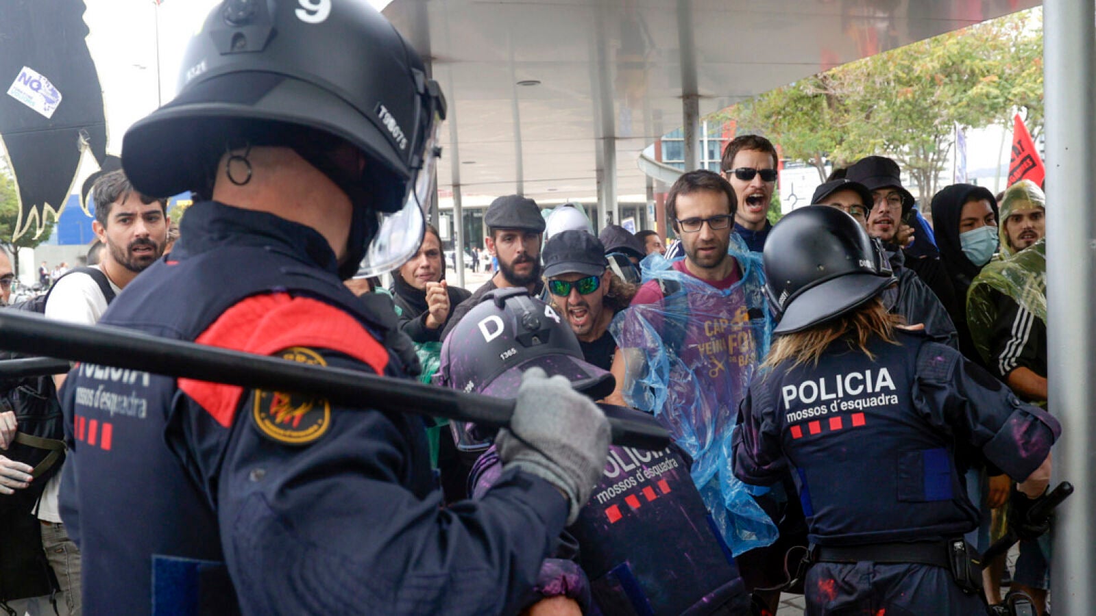 Activistas lanzan pintura a los asistentes de una feria inmobiliaria en Barcelona y alcanzan a los antidisturbios de los Mossos