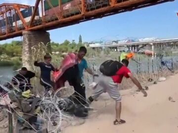 Migrantes sorteando los alambres