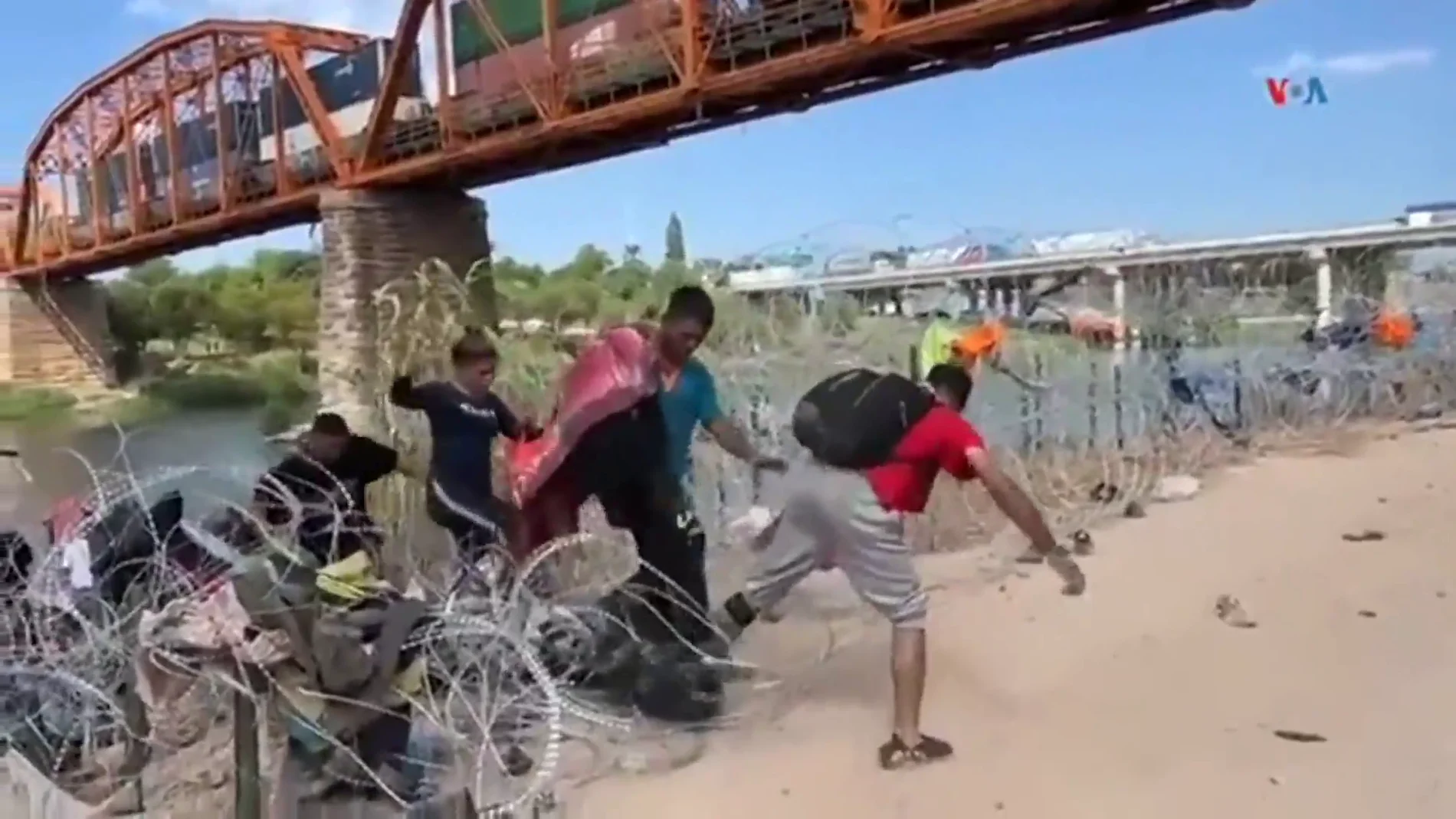 Migrantes sorteando los alambres