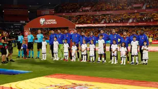 Los jugadores de la selección española escuchan el himno nacional antes de un partido
