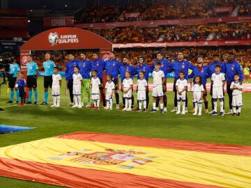 Los jugadores de la selección española escuchan el himno nacional antes de un partido