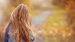 Ni&ntilde;a de espaldas en un campo