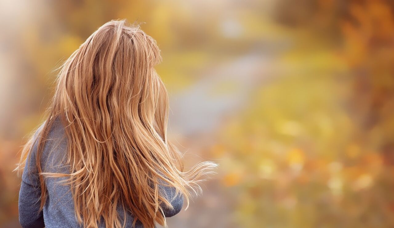 Ni&ntilde;a de espaldas en un campo