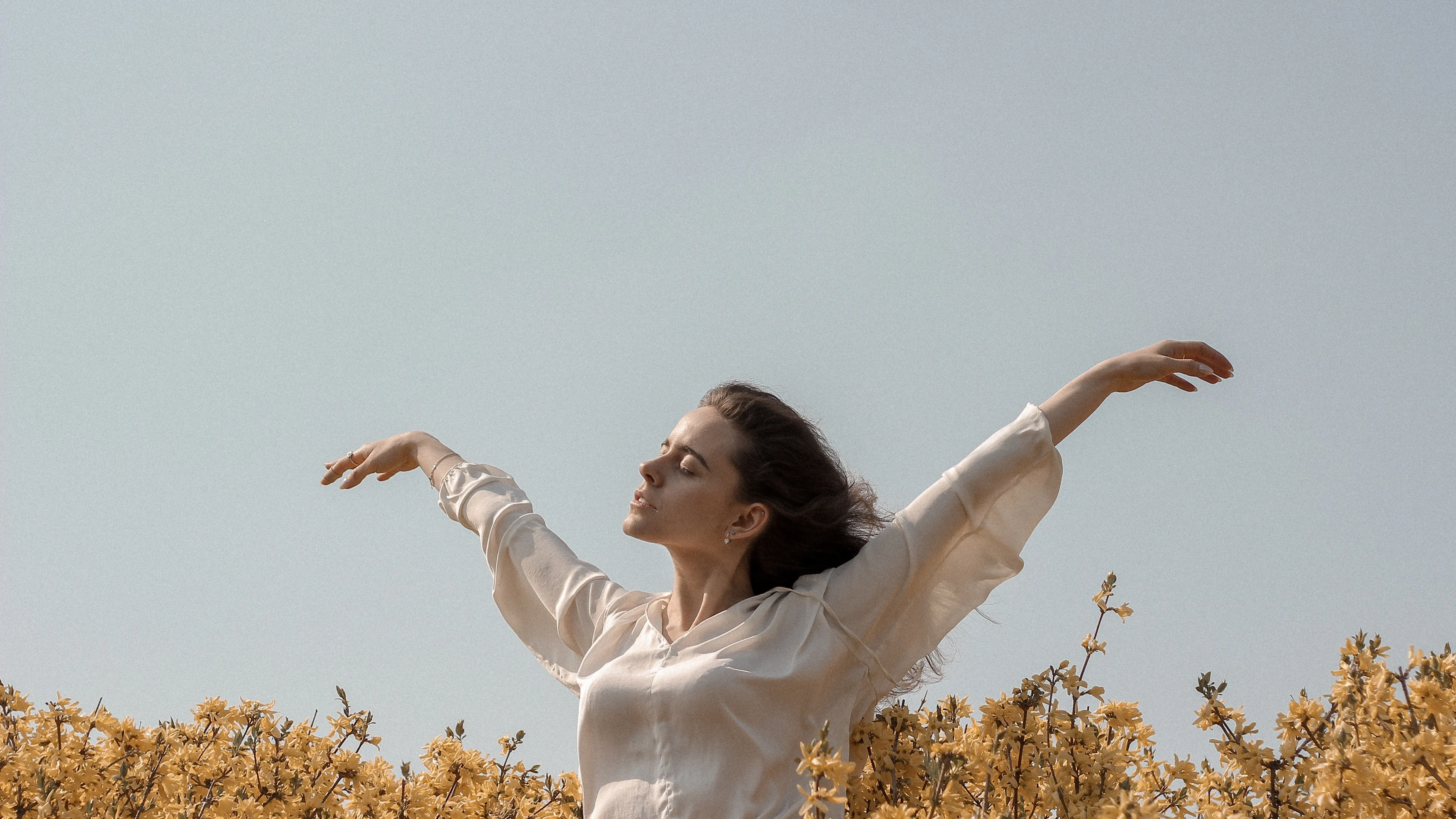 Mujer sintiendo el viento entre las flores del campo Mujer sintiendo el viento entre las flores del campo