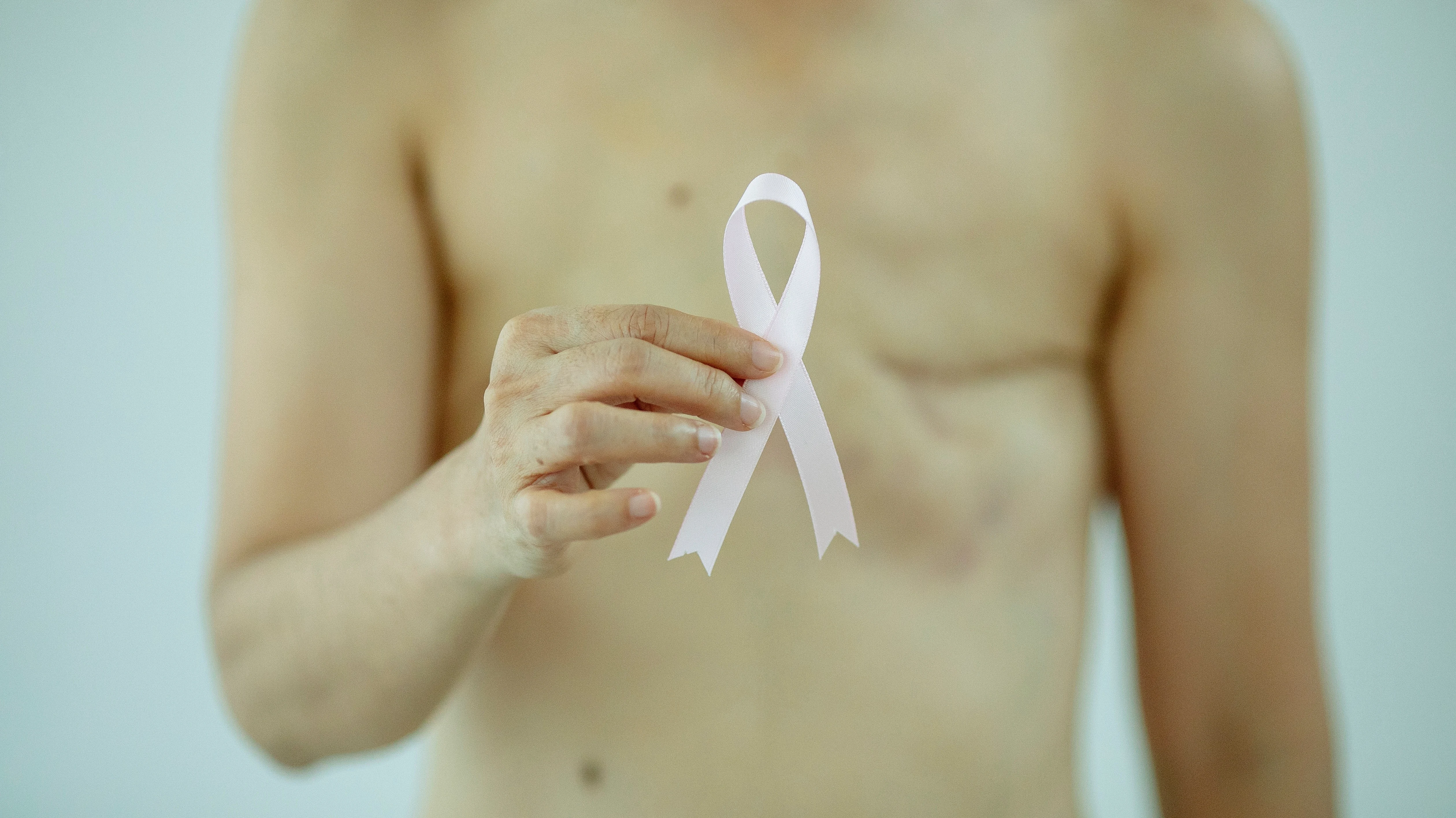 Mujer a la que le han realizado una mastectom&iacute;a sujeta un lazo rosa