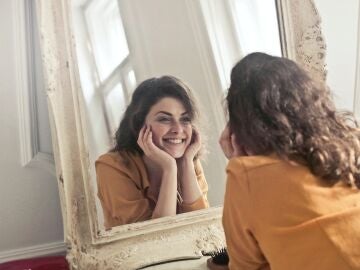 Una mujer se mira en el espejo.